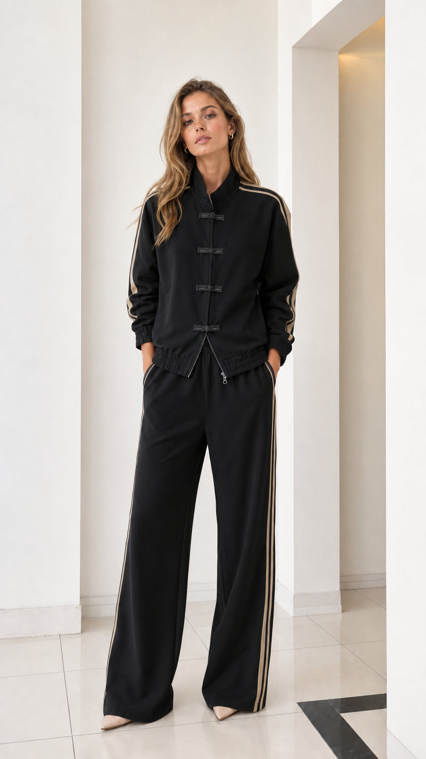 Full front view of women's black tracksuit set with contrast side stripes and frog buttons