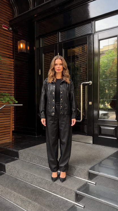 Front view of woman wearing black faux leather jacket and trouser set