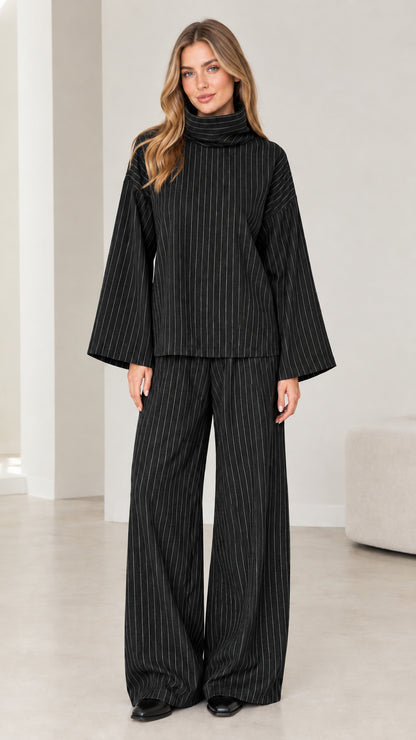 Woman wearing Black pinstripe turtleneck top and matching wide-leg trousers set