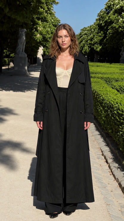 Model wearing black maxi trench coat and matching black wide-leg trousers