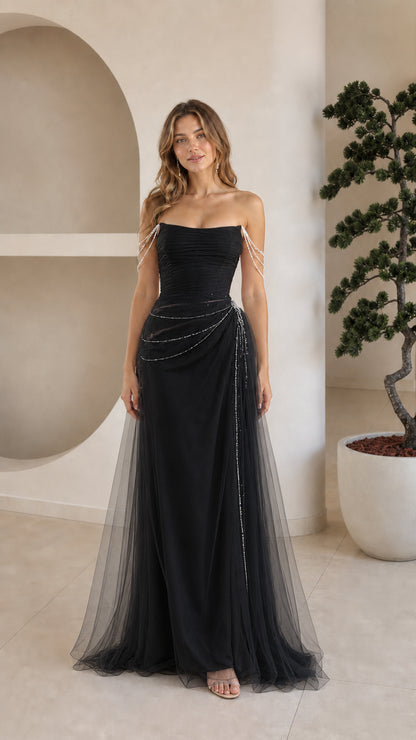 Front view of model wearing strapless black tulle evening gown with draped beading