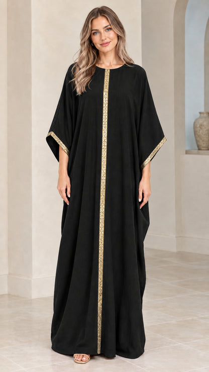 Full front view of model wearing black kaftan maxi dress with gold trim