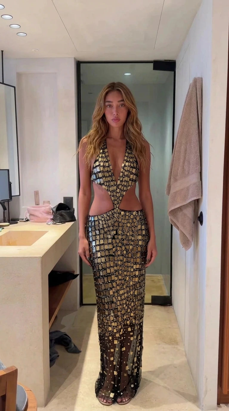 Model wearing black and gold embellished halter cutout maxi dress