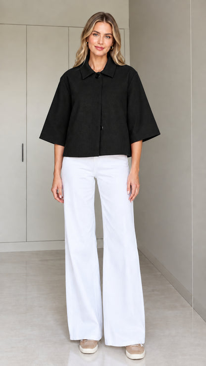 Front view of a woman wearing the cropped half-sleeve swing jacket in black