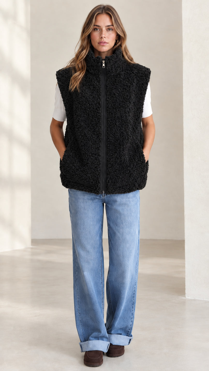 Front view of woman wearing black plush sherpa fleece zip-up vest