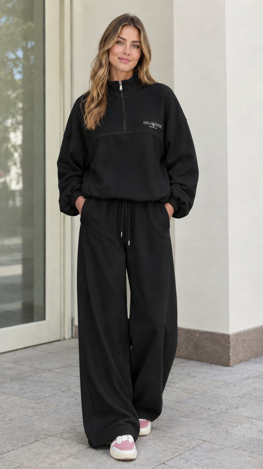 Woman wearing Black fleece quarter-zip pullover and wide-leg lounge pants set