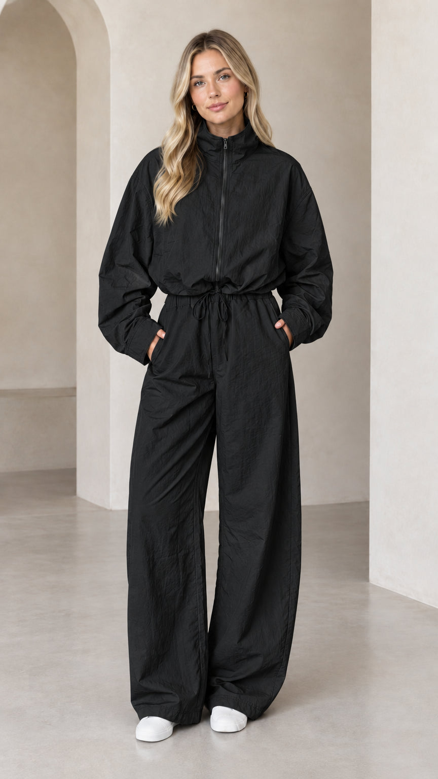 Front full-length view of woman wearing Black zip-up wide-leg utility jumpsuit