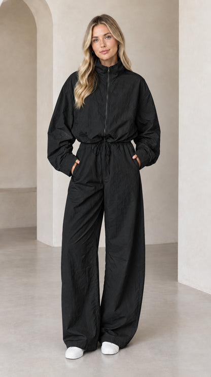 Front full-length view of woman wearing Black zip-up wide-leg utility jumpsuit