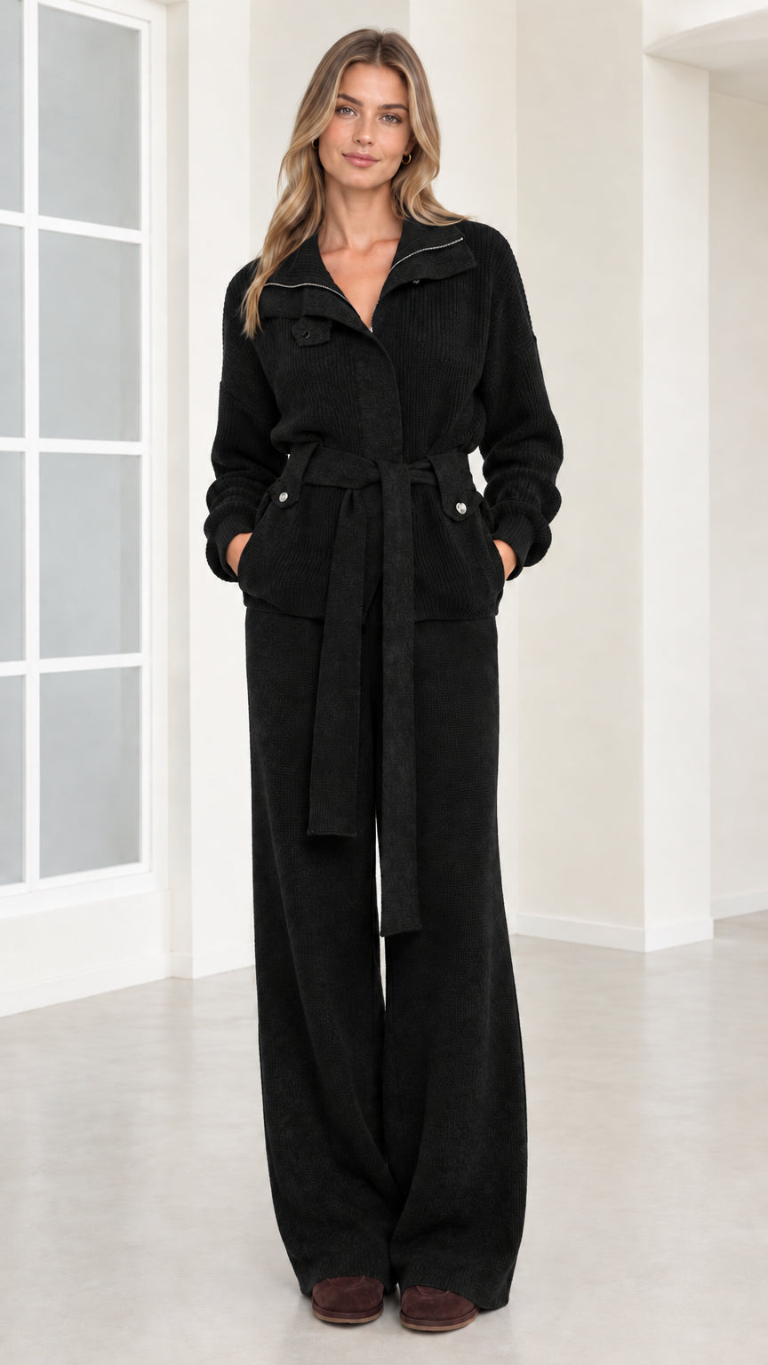 Front view of woman wearing black ribbed knit belted two-piece set