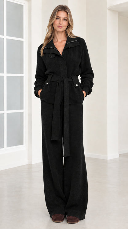 Front view of woman wearing black ribbed knit belted two-piece set