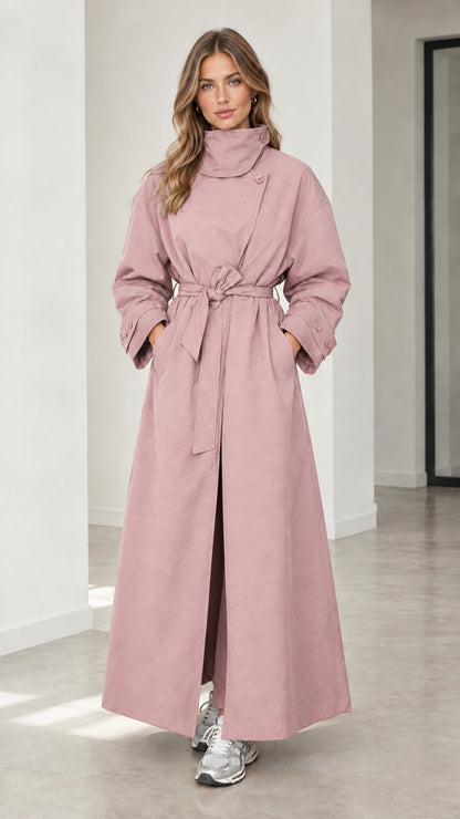 Front full view of woman wearing dusty pink high neck maxi trench coat with tie belt