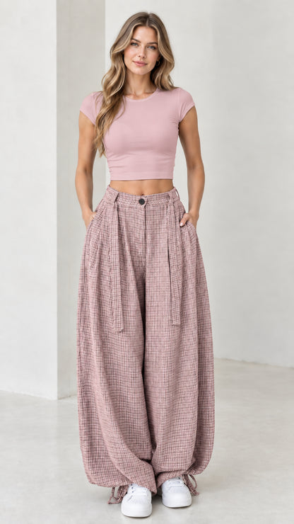 Front view of woman wearing dusty pink micro-plaid pleated wide leg pants
