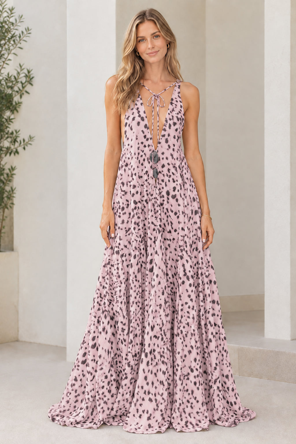 Model wearing light pink dotted print sleeveless tiered maxi dress