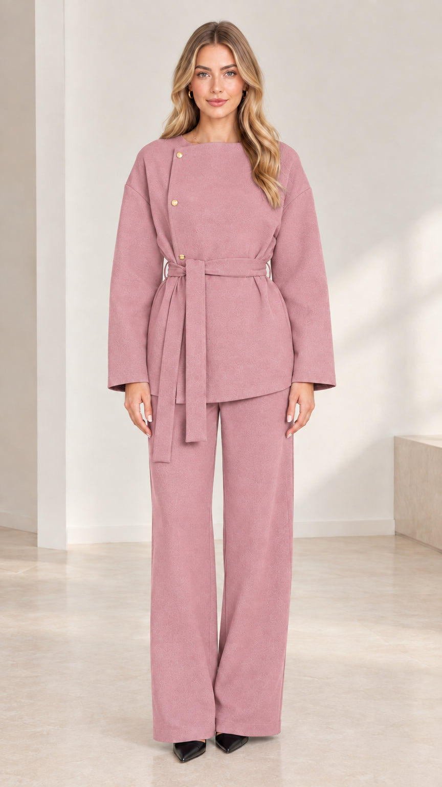 Full-length studio shot of model wearing dusty rose asymmetrical belted pant set