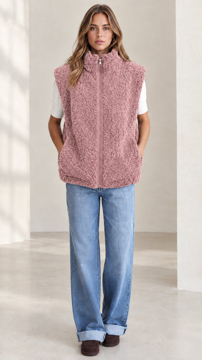 Front view of woman wearing dusty pink sherpa fleece zip-up vest