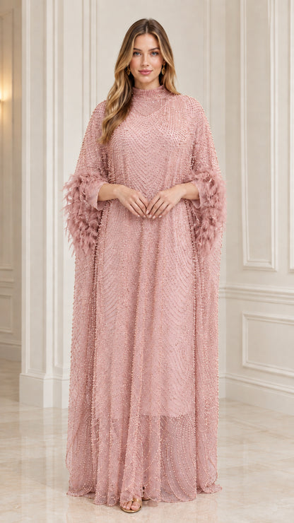 Model wearing Blush Pink sequin beaded kaftan evening dress with feather trim