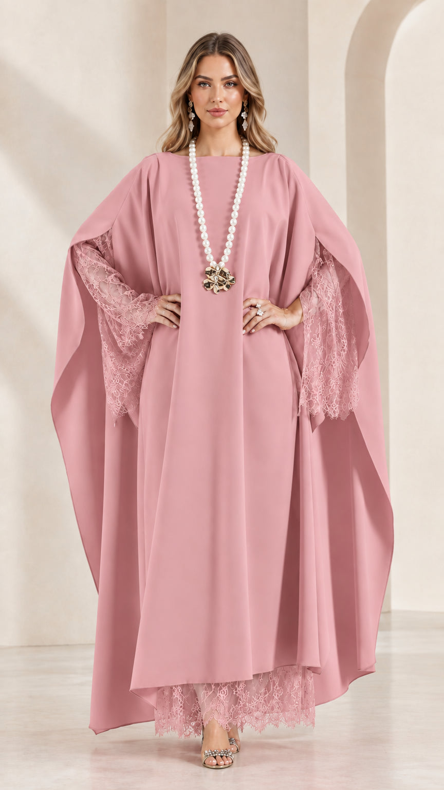 Front view of woman wearing blush pink lace-trimmed cape kaftan dress