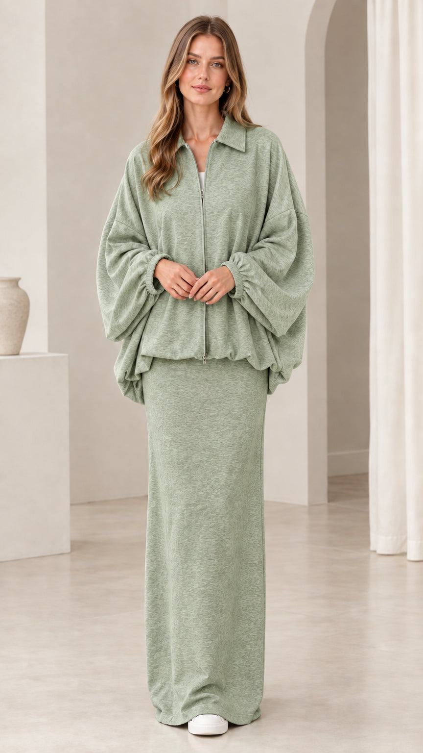 Model wearing sage green two-piece zip blouson jacket and long skirt set
