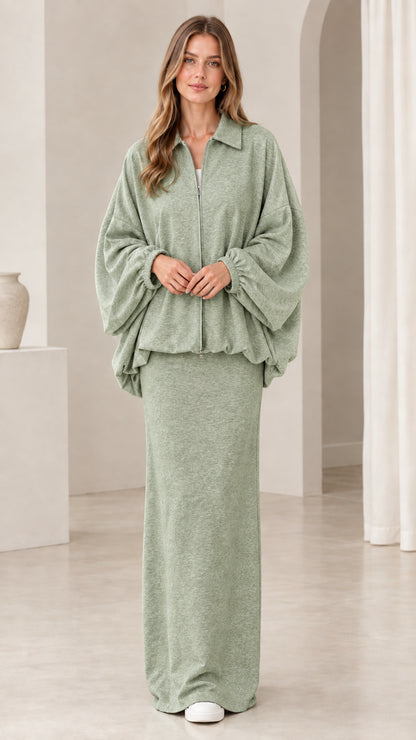 Model wearing sage green two-piece zip blouson jacket and long skirt set