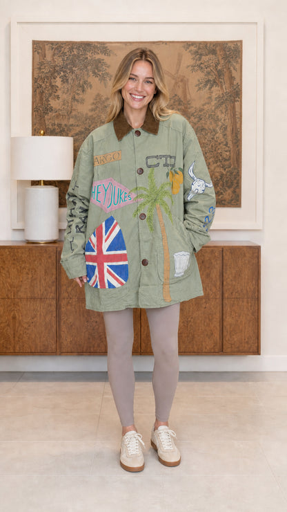 Model wearing sage green oversized travel graphic barn jacket