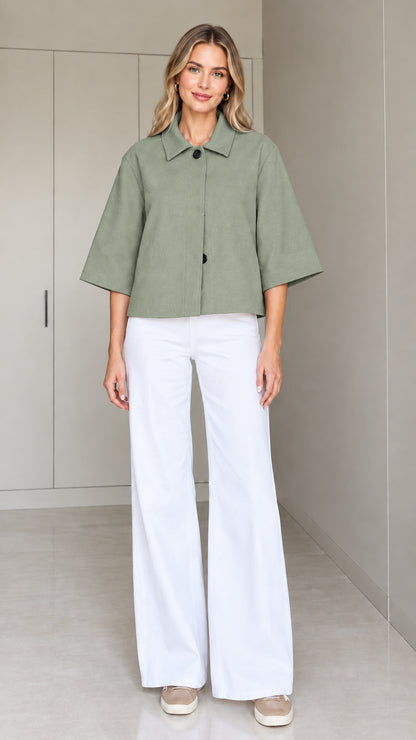 Front view of a woman wearing the cropped half-sleeve swing jacket in sage green