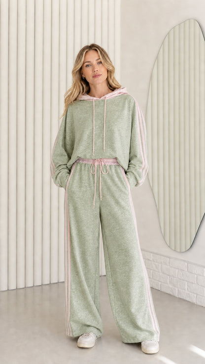 Woman wearing Sage Green two-piece tracksuit set with pink striped details