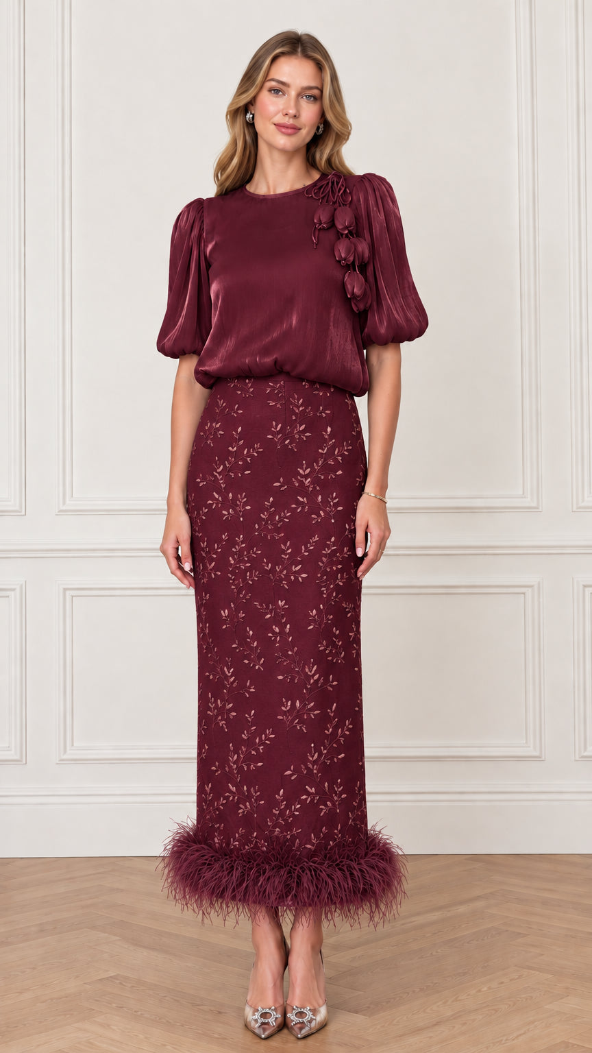 Model wearing Burgundy red satin-finish blouse and embroidered feather hem maxi skirt