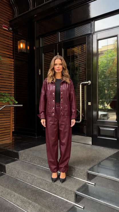 Front view of woman wearing burgundy faux leather matching jacket and pants