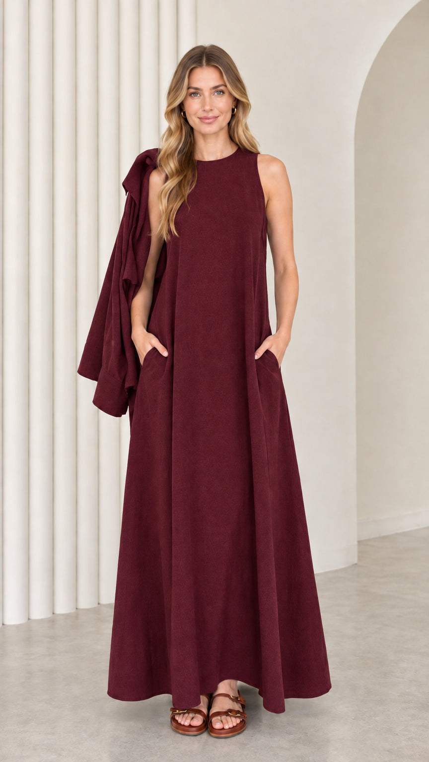Front full-length view of model wearing the burgundy sleeveless maxi dress with matching drape
