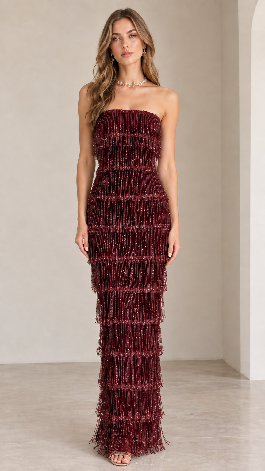 Front view of model wearing burgundy wine strapless tiered fringe evening gown