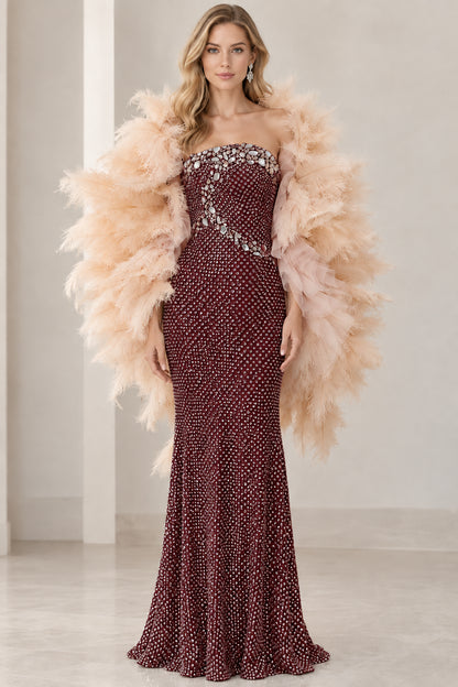 Front view of rich burgundy red strapless embellished gown with feather shawl