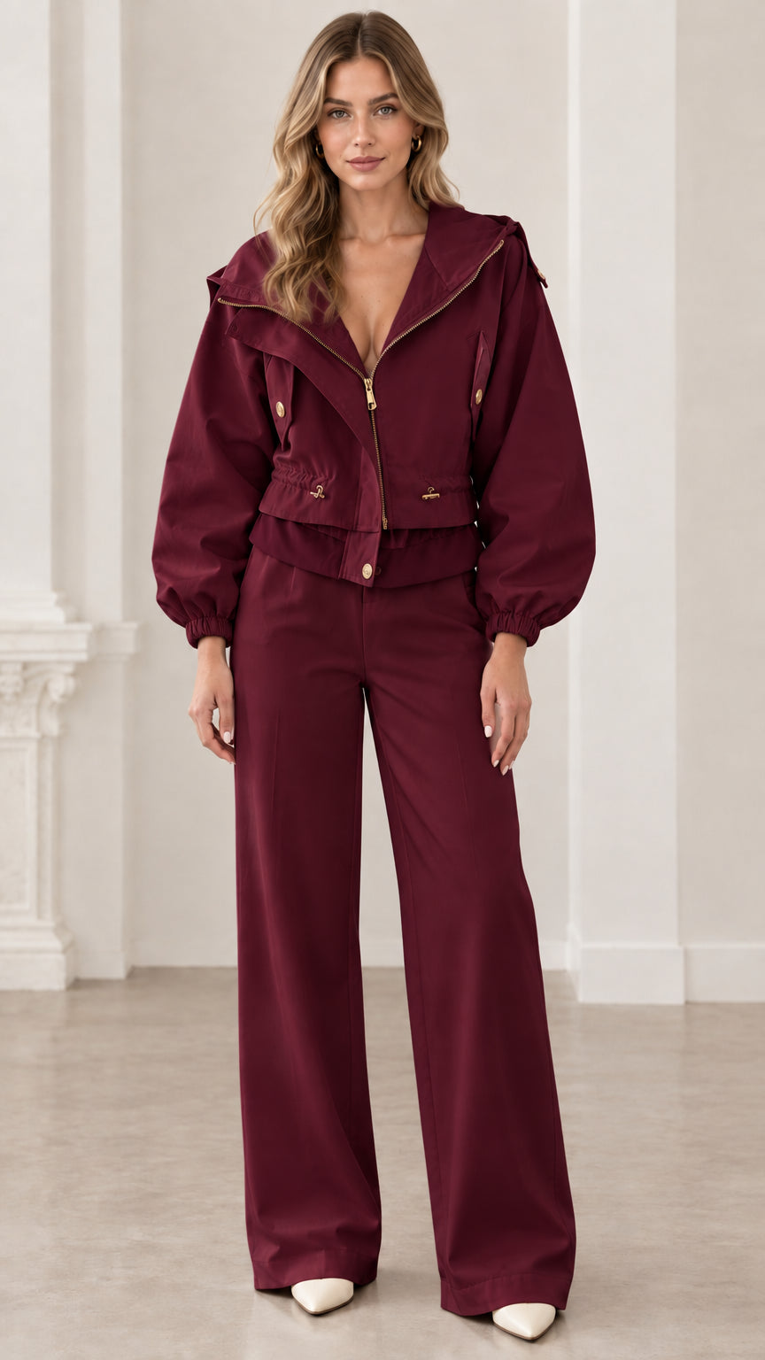 Front view of woman wearing burgundy wine cropped hooded utility jacket with matching trousers