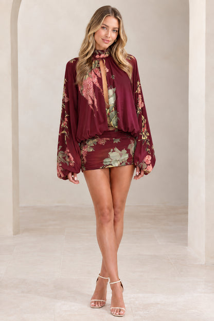 Woman wearing burgundy wine floral lantern sleeve high neck mini dress