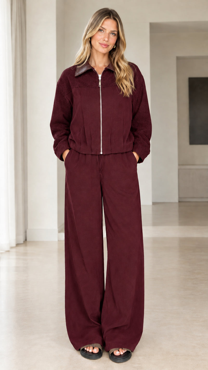 Front view of model wearing burgundy two-piece zip jacket and pants set
