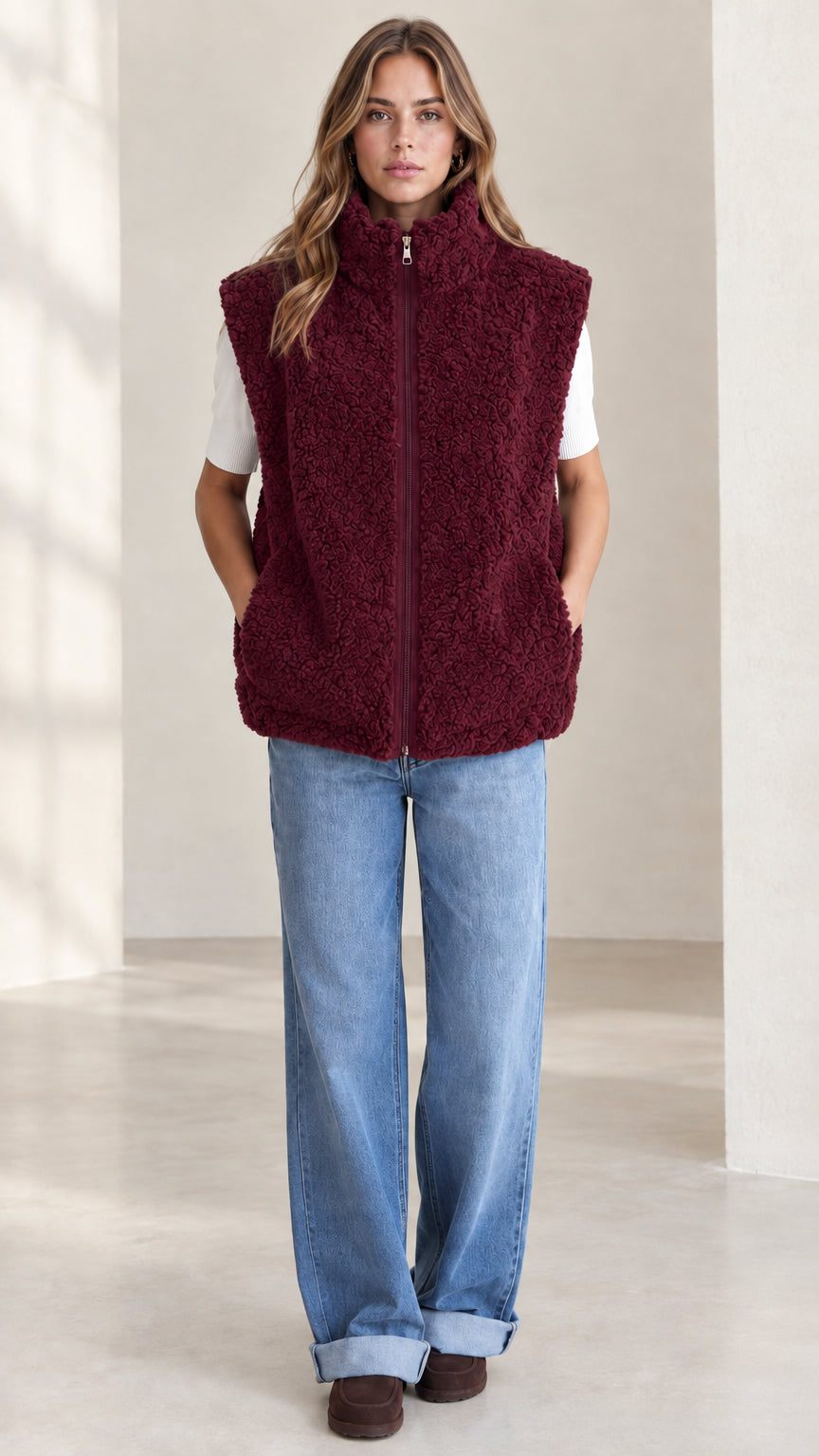 Front view of woman wearing burgundy sherpa fleece zip-up vest