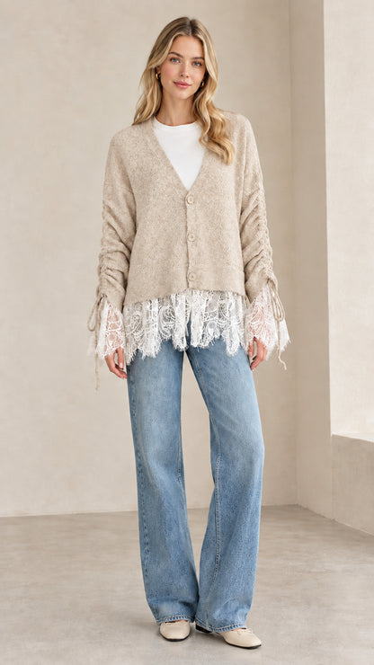 Front view of woman wearing beige oatmeal V-neck lace-trimmed knit cardigan