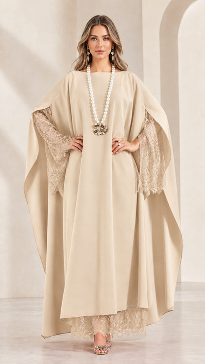 Front view of woman wearing elegant beige champagne cape sleeve maxi gown