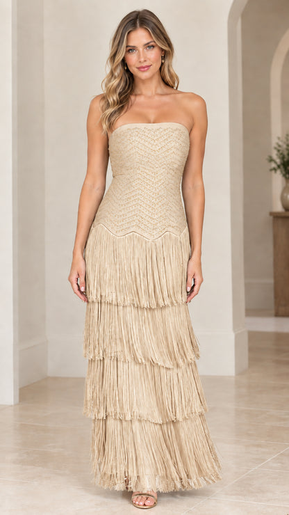 Front view of woman wearing champagne beige strapless tiered fringe maxi gown
