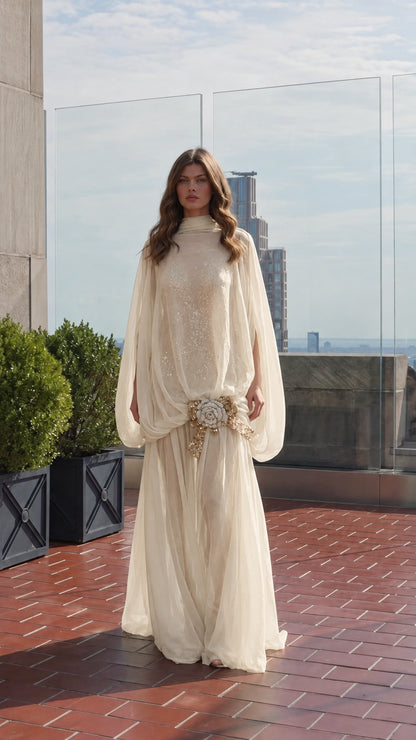 Model wearing champagne gold high-neck cape sleeve maxi evening dress