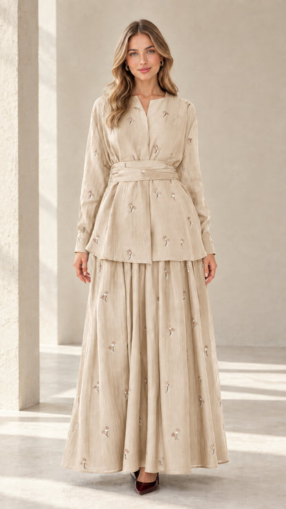 Model wearing beige cream embroidered belted tunic and flowing maxi skirt set