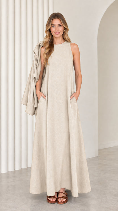 Front full-length view of model wearing the beige oatmeal sleeveless maxi dress with matching drape