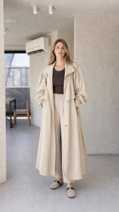 Model wearing light beige cream oversized maxi trench coat with lantern sleeves