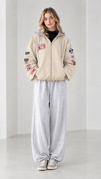 Front full view of beige cream zip-up hooded bomber jacket with sleeve patches